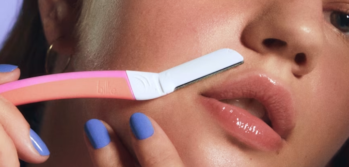 A girl using Billie Dermaplane to remove hair from her upper lip